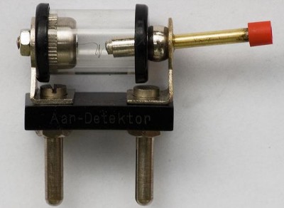 Detektor, fungující jako hrotová dioda, sestával ze skleněného pouzdérka, ve kterém byl uchycen galenitový krystal, do kterého se píchalo pružnou jehličkou aretovanou v kloubovém držáčku tak dlouho, až byl příjem optimální a dostatečně hlasitý. Poté bylo možné ještě drobné doladění otočným kondenzátorem, což bylo potřeba hlavně v případech, kdy naladěný program rušila další blízká silnější stanice. Pochopitelně bylo nutno krystalku, mimo připojení ke kvalitní drátové anténě, také dobře uzemnit. Jinak jste se poslechu rádia nedočkali. Nastavování detektoru vyžadovalo neskutečnou trpělivost, často stačilo pak o naladěný přijímač neopatrně zavadit rukou a celá legrace s pícháním do krystalu se opakovala nanovo. Detektor je na snímku zobrazen zhruba ve skutečné velikosti, dokonce se dal /za pár korun/ ještě okolo roku 1961-2 koupit v prodejnách s elektropotřebami. Vím to dobře, krystalku jsem stavěl jako mladý hoch také…